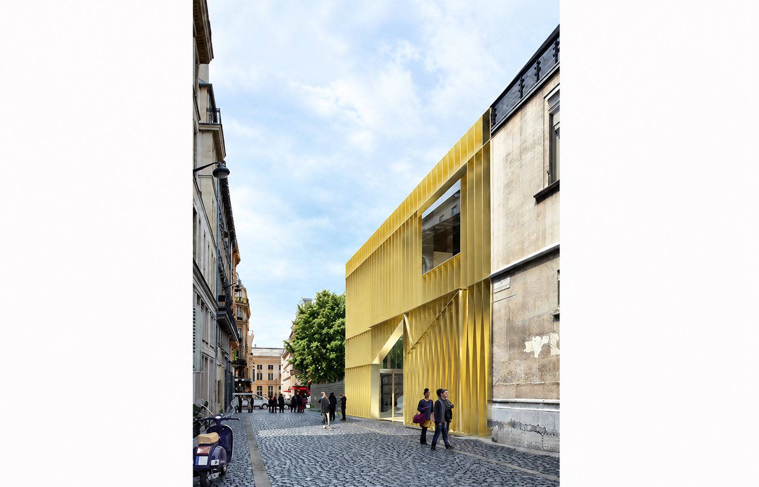 Rendu du projet. Image de synthèse d'un bâtiment moderne à façade dorée plissée insérée entre des immeubles anciens, dans une rue pavée où marchent quelques passants.